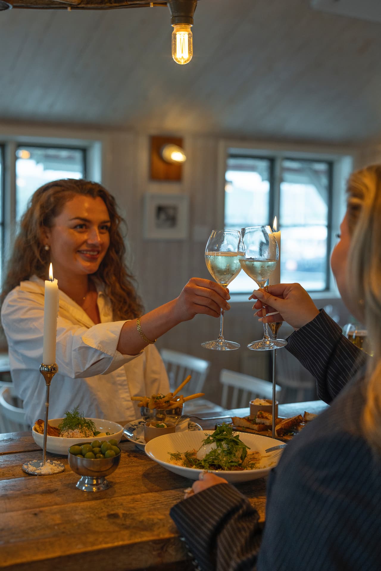 Gäster skålar vid levande ljus på Dyröns Värdshus